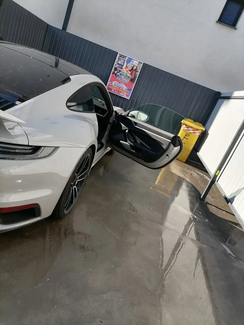 Porsche 911 alb cu ușa deschisă, la curățat interior