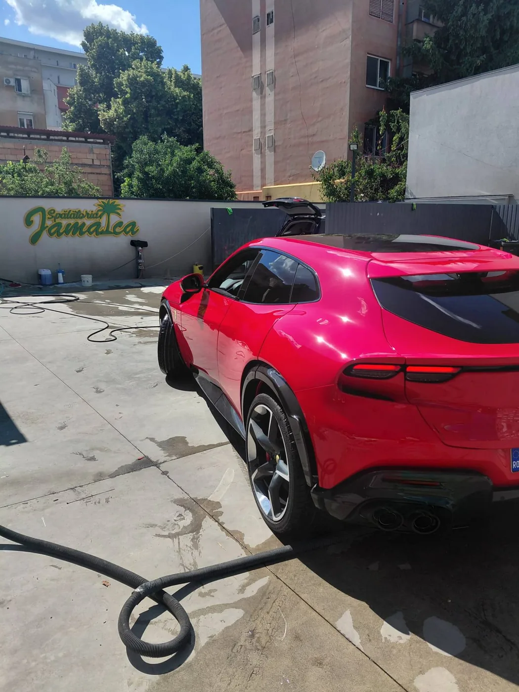 Ferrari Purosangue roșu, proaspăt spălat în curtea Spălătoriei Jamaica