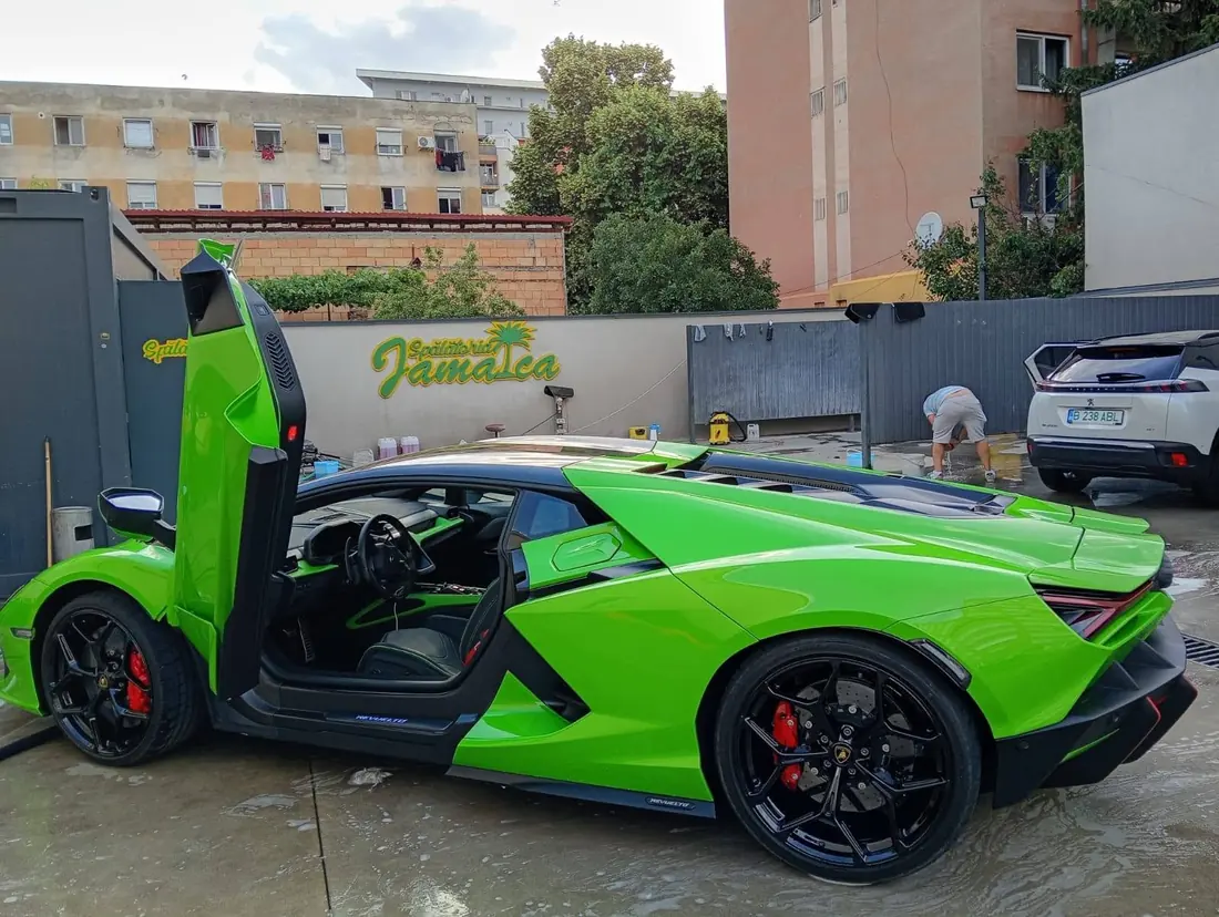 Lamborghini Revuelto verde cu ușile deschise în curtea Spălătoriei Jamaica