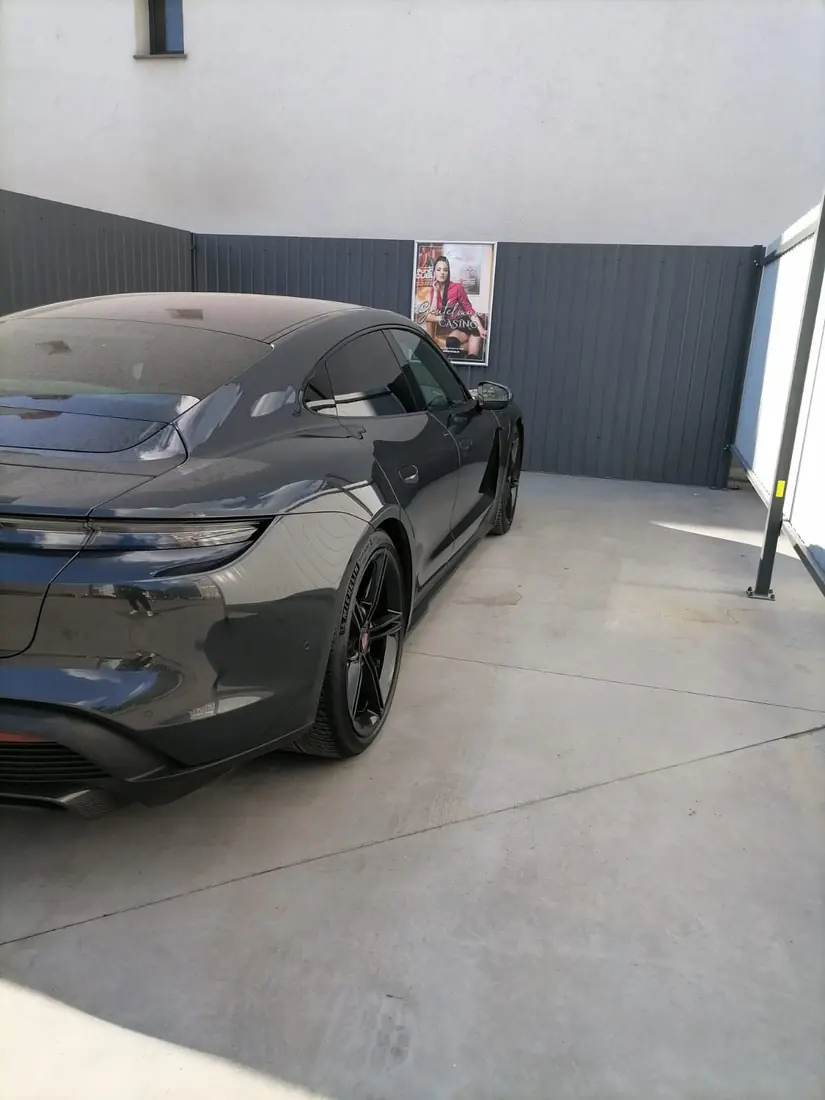 Porsche Taycan gri între panourile antracit ale spălătoriei