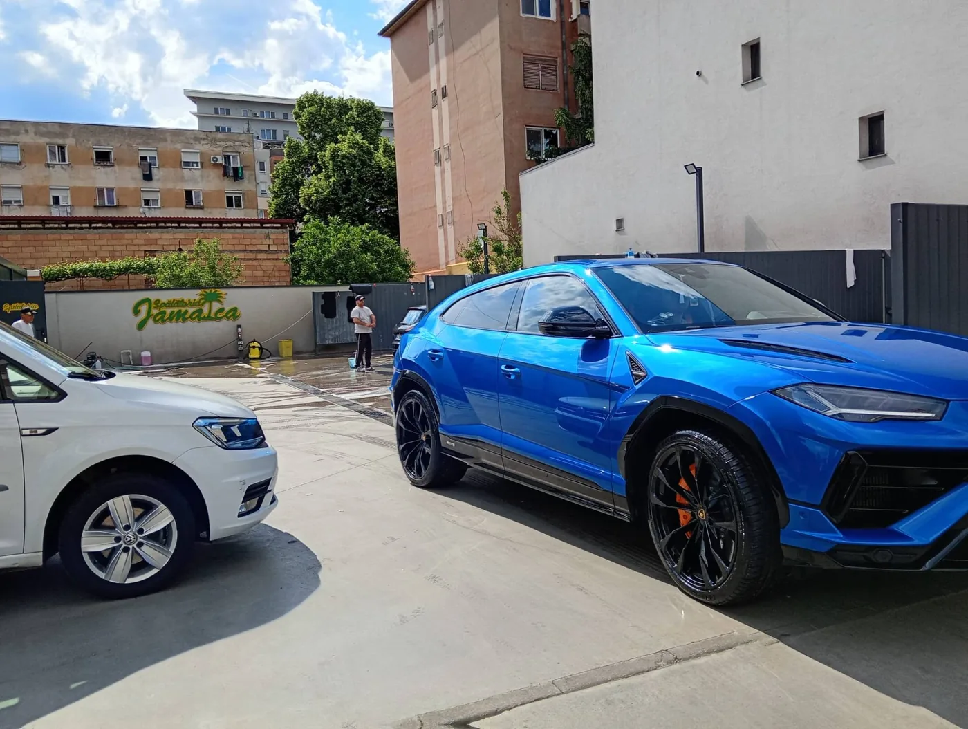 Lamborghini Urus albastru lângă sigla Spălătoriei Jamaica